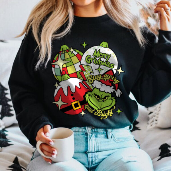 Person wearing a pink Grinch Christmas tee with festive ornaments design, ideal for holiday celebrations.