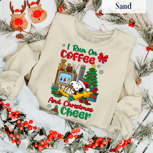 Person wearing a Snoopy I Run on Coffee and Christmas Cheer shirt at a Christmas party, enjoying festive winter vibes